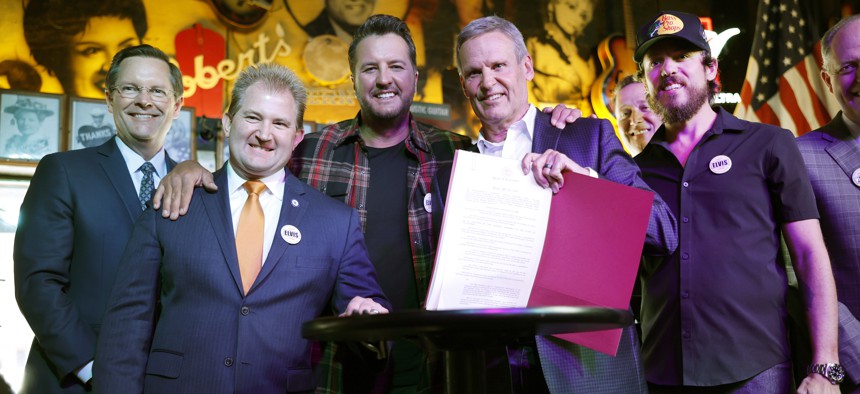 Tennessee Gov. Bill Lee (second from right) celebrates signing the state's ELVIS Act into law earlier this year.