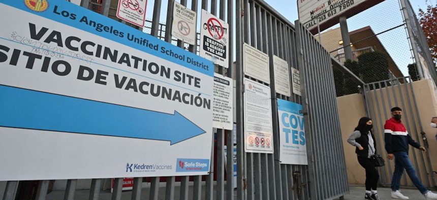 People leave a COVID-19 testing and vaccination site at a public school in Los Angeles on Jan. 5, 2022.