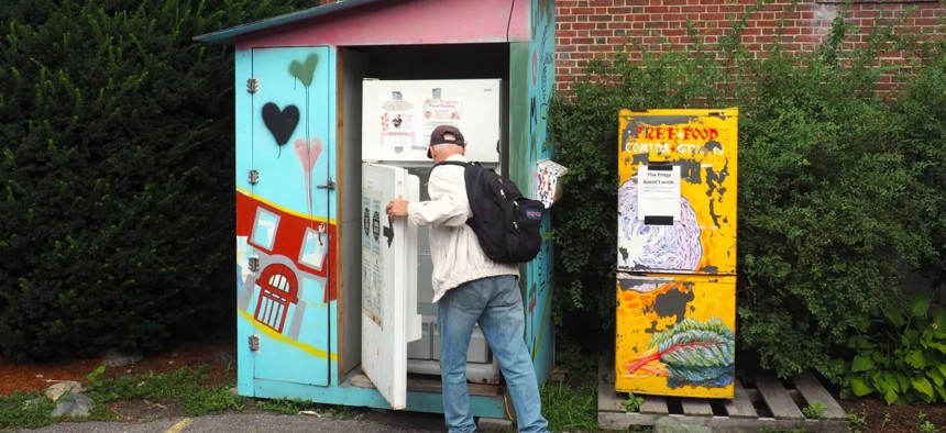 A person reaches into the Allston-Brighton community fridge in Boston on Aug. 7, 2024. 