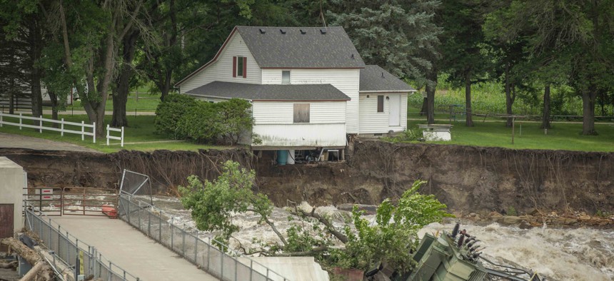 A house on the edge of the property looks ready to fall into the river as the Rapidan Dam sits broken at the Blue Earth River in Waterville, Minnesota on June 25.