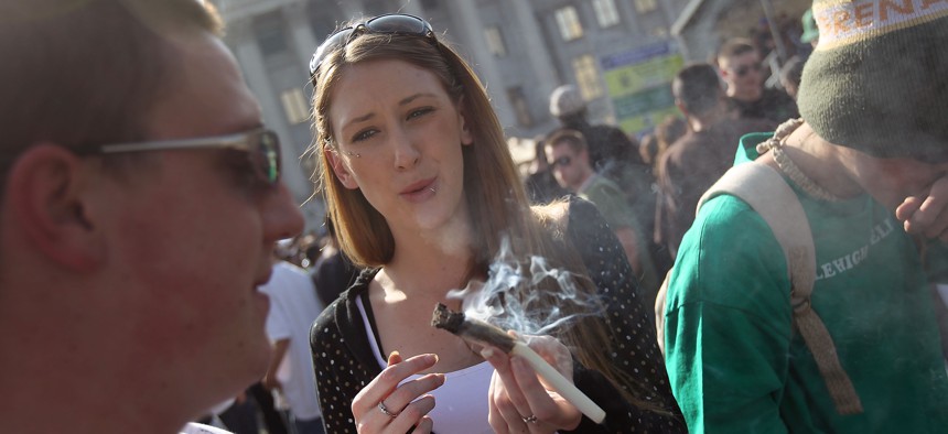 A woman passes a joint at a pro-marijuana "4/20" celebration in front of the state capitol building on April 20, 2010 in Denver.