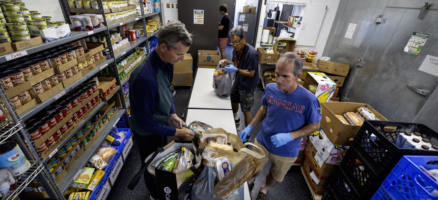 Volunteers pack bags of donated food to give to families at St. Margaret's Center in Inglewood, Calif., in November 2023.