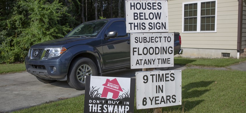 Signs warn potential homebuyers about flooding issues in the Starcreek Circle neighborhood of Myrtle Beach, South Carolina on September 19, 2022.