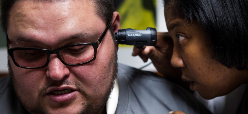 Physician's assistant Renee Pettis does an exam on Jose Mendoza at Martin Luther King, Jr., Health Center on Thursday, Nov. 19, 2015, in Houston.