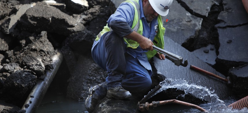 Water utility worker tries to stem the flow of water from a ruptured pipe in Los Angeles.