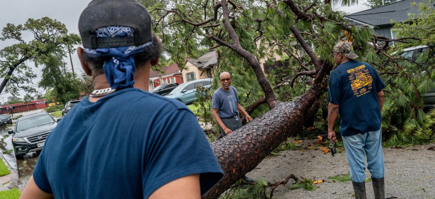 Residents assess a fallen tree in their in their neighborhood after Hurricane Beryl swept through the area on July 8, 2024, in Houston, Texas.