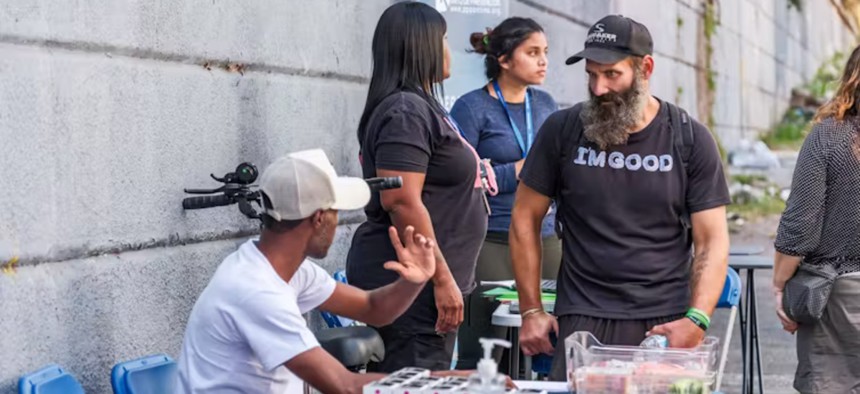 Outside the Prevention Point van in Philadelphia, a treatment specialist distributes Narcan, a nasal spray used to reverse opioid overdoses.