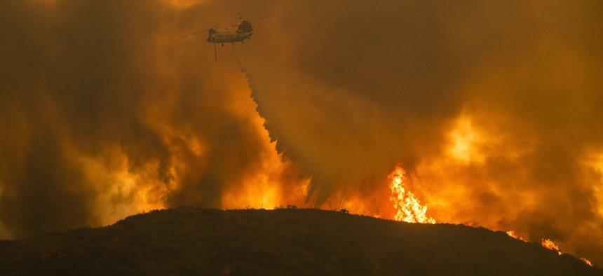 A Cal Fire helicopter drops water on the Airport Fire, which is burning in Southern California in Orange and Riverside counties. 