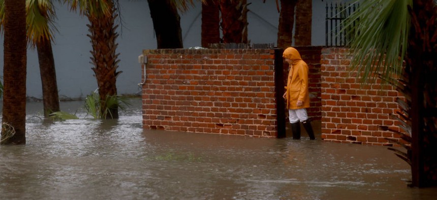 A person walks through a flooded street caused by the rain and storm surge from Hurricane Debby on Aug. 5, 2024, in Cedar Key, Florida. 