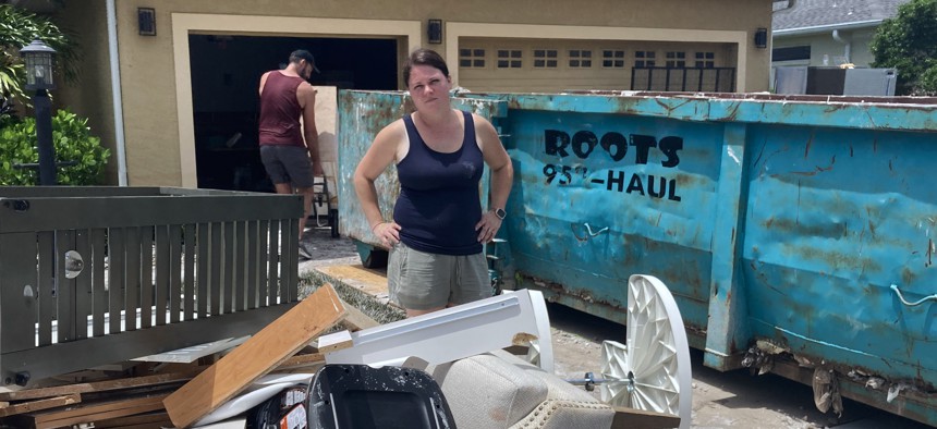 Kelsey Blanton stands in front of her Sarasota, Fla., home, which was flooded by rains from Tropical Storm Debby last month. In disaster-prone areas like Florida, home insurance rates have increased sharply, with some insurers pulling out of the market entirely.