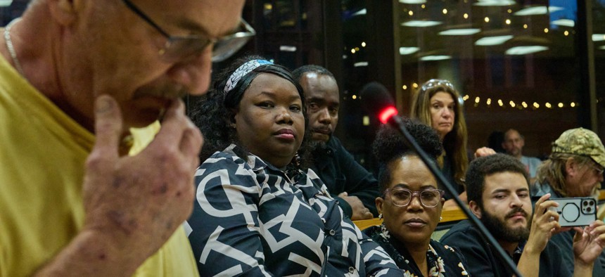 Mia Perez, center-left, a Haitian-Cuban-American translator and attorney from Springfield, Ohio, and business leaders, listen as a resident denounces the town's growing Haitian population during town hall meeting on Sept. 24, 2024. 