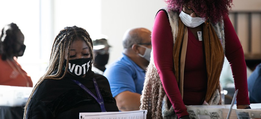 Fulton County workers count absentee ballots at State Farm Arena on November 6, 2020, in Atlanta.