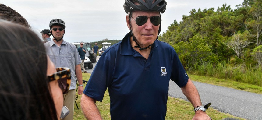 President Joe Biden stops to talk to reporters during a bike ride in Gordons Pond State Park in Rehoboth Beach, Delaware on July 10, 2022.