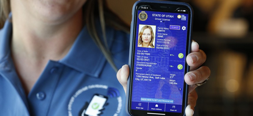 A Utah Department of Motor Vehicle employee shows a sample of a digital driver's license on a mobile phone at a demonstration in August 2021 in Salt Lake City. The Transportation Security Administration is finalizing plans to allow for the use of mobile driver's licenses at airport security checkpoints.