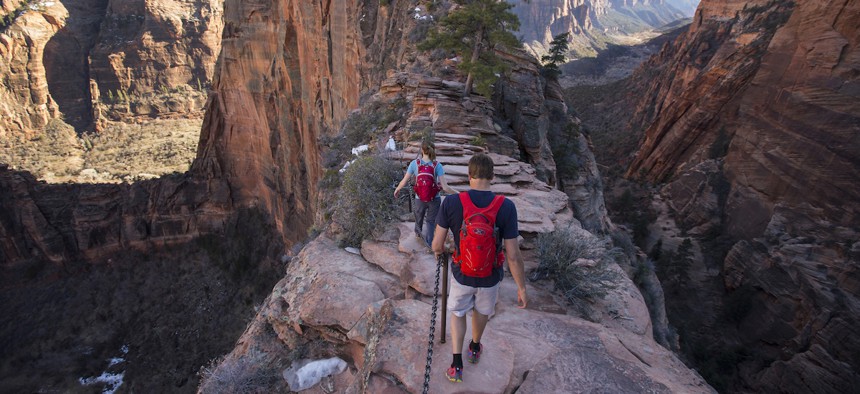 A man and woman hiking Angels Landing in Zion national Park.