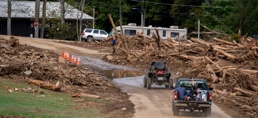 Motorists drive past flood damage along Craig Creek in the aftermath of Hurricane Helene on Sept. 30, 2024, near Black Mountain, North Carolina. 