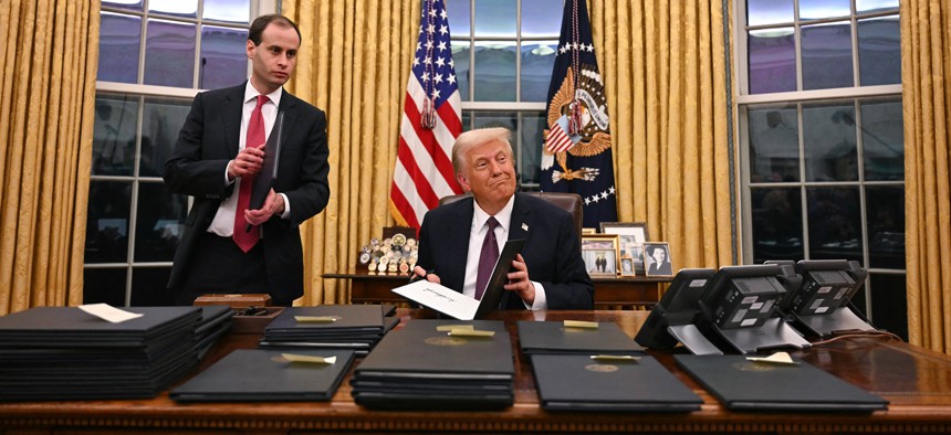 US President Donald Trump signs executive orders in the Oval Office of the WHite House in Washington, DC, on January 20, 2025.