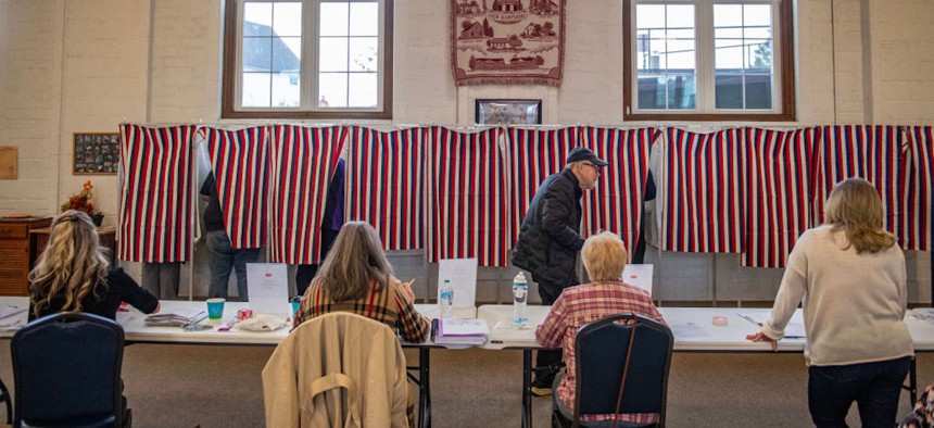 Poll workers check in voters as people vote in booths at the CD McIntyre Building in Whitefield, New Hampshire, on Nov. 5, 2024. 