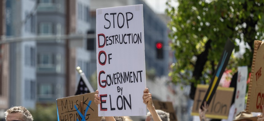 Protestors outside the former SpaceX headquarters in California call for an end to the federal Department of Government Efficiency.