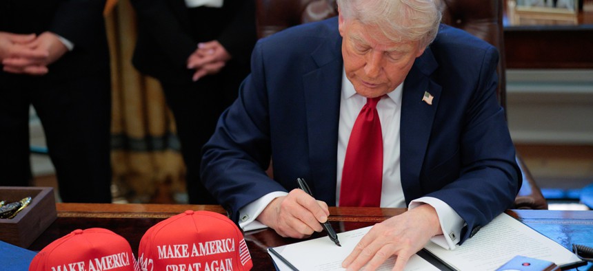 President Donald Trump signs an executive order in the Oval Office at the White House on April 23, 2025 in Washington, DC.