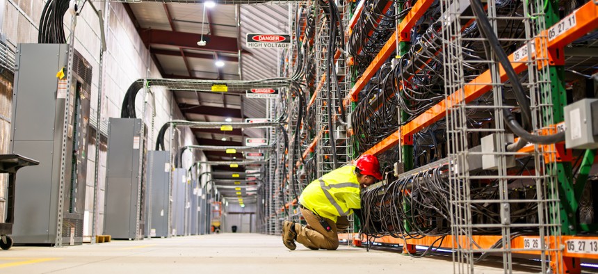 A technician wearing PPE working on racks of equipment in a data center in Stutsman County, North Dakota.