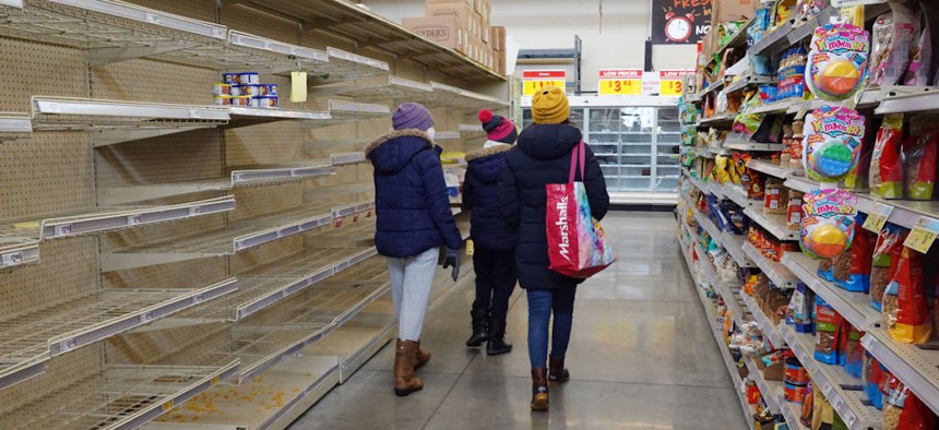 Shoppers walk past a bare shelf as people stock up on necessities at the H-E-B grocery store on Feb. 18, 2021, in Austin, Texas. Winter Storm Uri brought historic cold weather and power outages to the state.