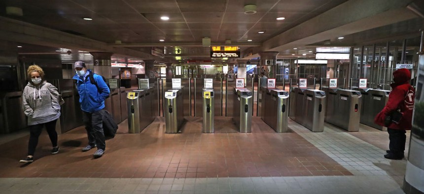 Commuters exit the South Station MBTA train "T" station in Boston on Dec. 7, 2020. 