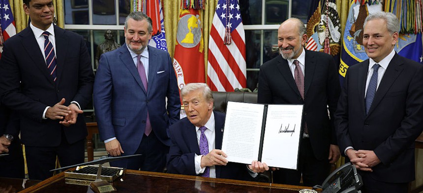 President Donald Trump displays a signed executive order that curbs states' ability to regulate artificial intelligence on Dec. 11, 2025, in Washington, DC.