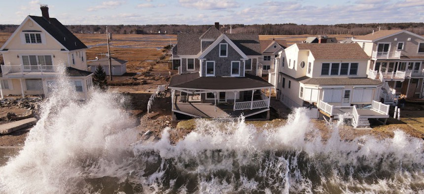 A wave breaks against a sea wall in front of homes along Wells Beach in Wells, Maine, on Sunday, Jan. 14, 2024.