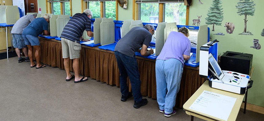 Voters fill out their ballots at a polling place in the Tamarack Nature Center on Aug. 11, 2026 in White Bear Township, Minnesota.