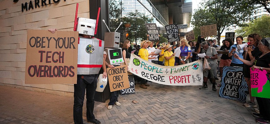 Charles Couchman, left, protests against data center development outside the Austin Marriott Downtown on Wednesday, Sept. 2, 2026, in Austin, Texas.