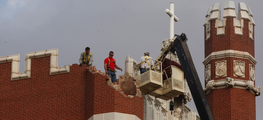 Maintenance workers inspect damage to Benedictine Hall at St. Gregory's University in Shawnee, Oklahoma, on Nov. 6, 2011. Two earthquakes in less than 24 hours caused a tower to topple and damaged the other three.