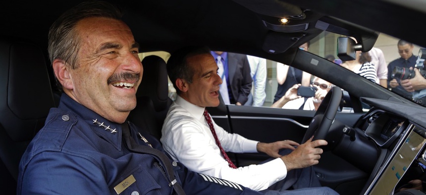 Los Angeles Police Chief Charlie Beck, left, and Mayor Eric Garcetti sit inside a police car during a news conference announcing the city's transition to green energy vehicles for its fleet in September 2015.