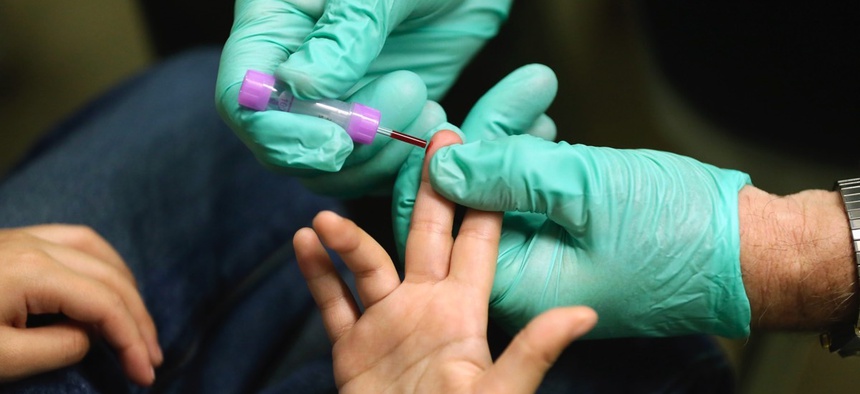 Registered nurse Brian Jones draws a blood sample from a student at Eisenhower Elementary School in Flint, Mich. The students were being tested for lead after the metal was found in the city's drinking water.