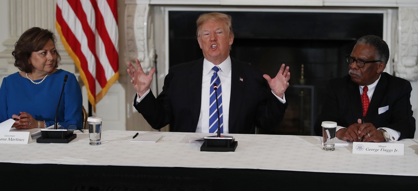 President Donald Trump joined by New Mexico Gov. Susana Martinez, left, and Vicksburg, Miss., Mayor George Flaggs, Jr., right, speaks in the State Dining Room of the White House in Washington, Monday, Feb. 12, 2018, during a meeting about infrastructure.