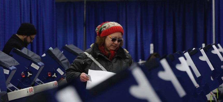 Chicago resident Sonja Russell walks up to a voting machine to cast her ballot in Illinois primary elections at the city's new early voting super site downtown on March 13.