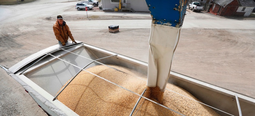 Terry Morrison watches as soybeans are loaded into his trailer at the Heartland Co-op on April 5 in Redfield, Iowa.