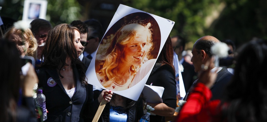 A woman holds a photo of Marsy Nicholas, whom Marsy’s Law was named for, during a 2013 victims’ rights march and rally in Santa Ana, California.