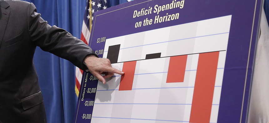 In this May 13, 2016, file photo, California Gov. Jerry Brown gestures to a chart showing possible future deficit spending as he discusses his revised 2016-17 state budget plan in Sacramento, Calif.