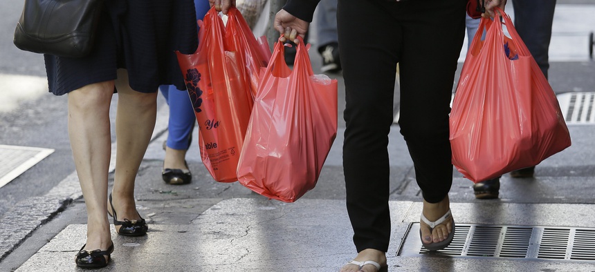 In this Sept. 20, 2016, file photo, women walk with plastic bags through Chinatown in San Francisco. California was the first state to enact a staetwide ban on plastic bags.