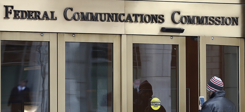 A person with a smart phone enters the Federal Communications Commission (FCC) in Washington on Dec. 14, 2017.
