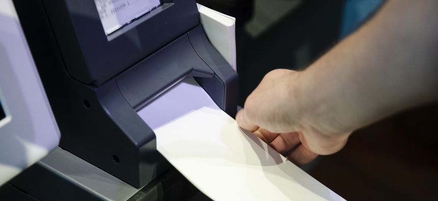 In this June 13, 2019, photo, Steve Marcinkus, an Investigator with the Office of the City Commissioners, demonstrates the ExpressVote XL voting machine at the Reading Terminal Market in Philadelphia.