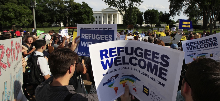 In this June 20, 2017 file photo, Refugees and community activists gather in front of the White House in Washington.