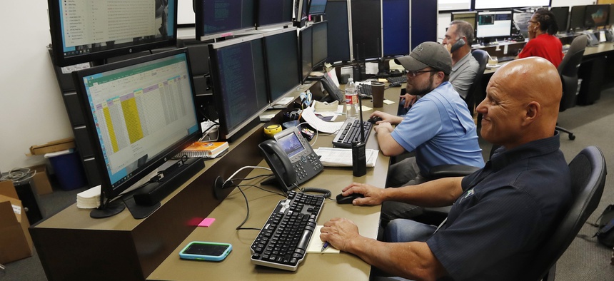 In this Sept. 12, 2019, photo, monitors check screens in the Governor's Office of Information Technology in Denver. Some cybersecurity professionals are concerned insurance policies designed to mitigate ransomware attacks might be encouraging hackers.