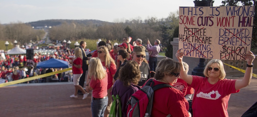 Teachers from across Kentucky gather outside the state Capitol to rally for increased funding and to protest changes to their state funded pension system, Friday, April 13, 2018, in Frankfort, Ky.