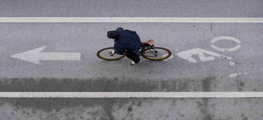 In this Monday, March 14, 2016, photo, a cyclist rides in a bike lane on a downtown street, in Des Moines, Iowa.