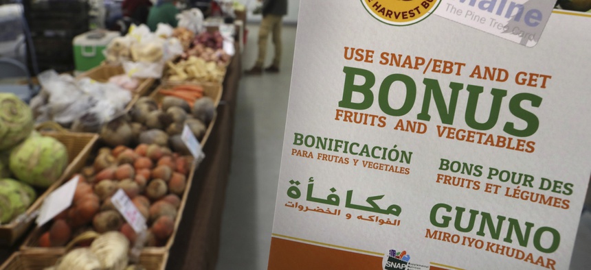 In this Friday, March 17, 2017, file photo, a sign advertises a program that allows food stamp recipients to use their EBT cards to shop at a farmer's market in Topsham, Maine.