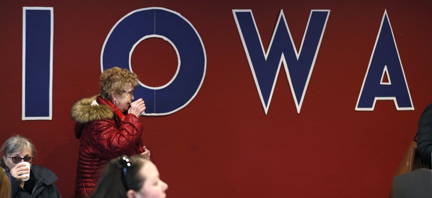 The U.S. Conference of Mayors will be co-sponsoring a presidential candidate forum in Iowa later this week, on Dec. 6. Here a woman is seen drinking coffee at an unrelated campaign event in the state.