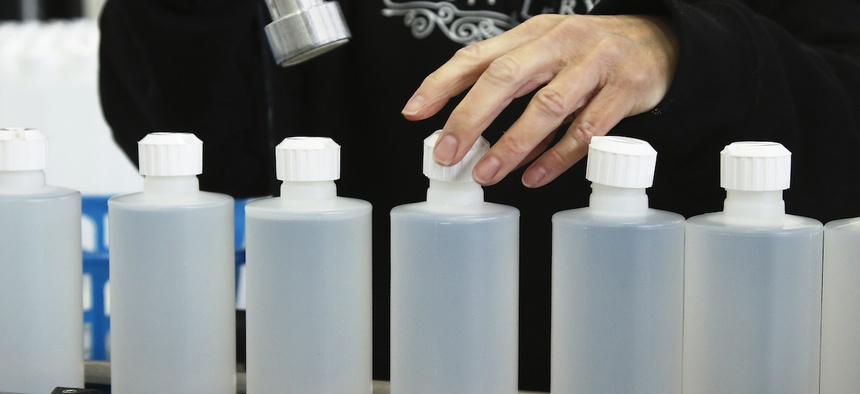 Rhonda Gillett caps bottles of hand sanitizer at the Prairie Distillery, which has switched from making liquor to making hand sanitizer due to the coronavirus pandemic, in Guthrie, Okla., Saturday, March 21, 2020.