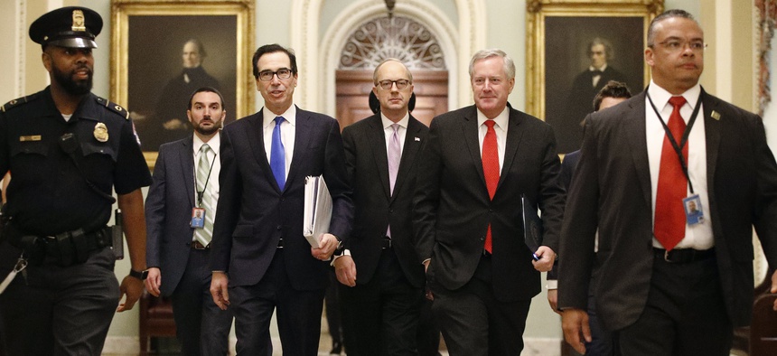 Treasury Secretary Steven Mnuchin, left, accompanied by White House Legislative Affairs Director Eric Ueland and acting White House chief of staff Mark Meadows, walks to the offices of Senate Majority Leader Mitch McConnell on Capitol Hill in Washington.